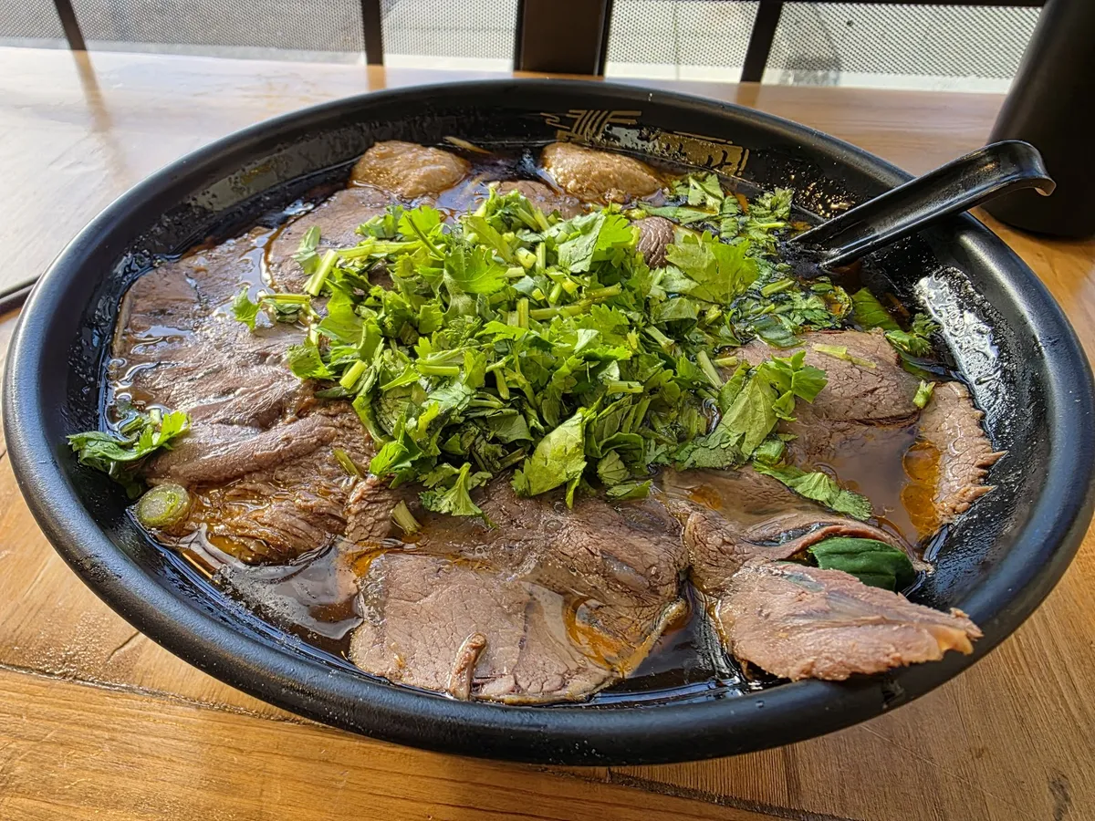 Bowl of beef noodle soup with cilantro